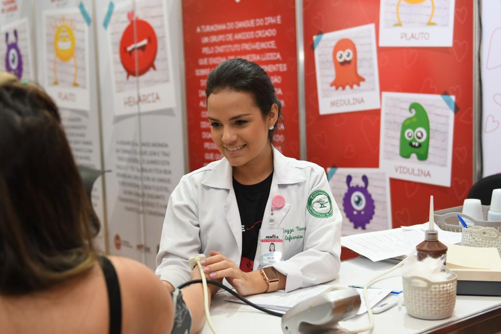 a imagem mostra uma mulher colhendo sangue de um doador